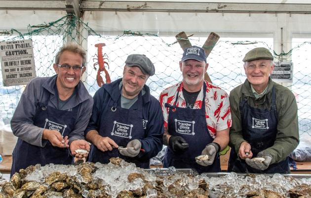 Four people shucking oysters 